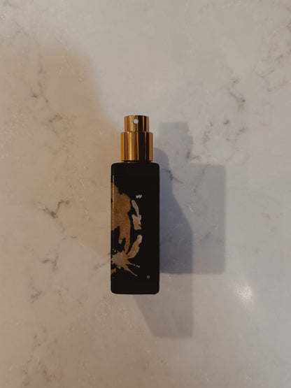 Black and gold spray bottle on a marble surface