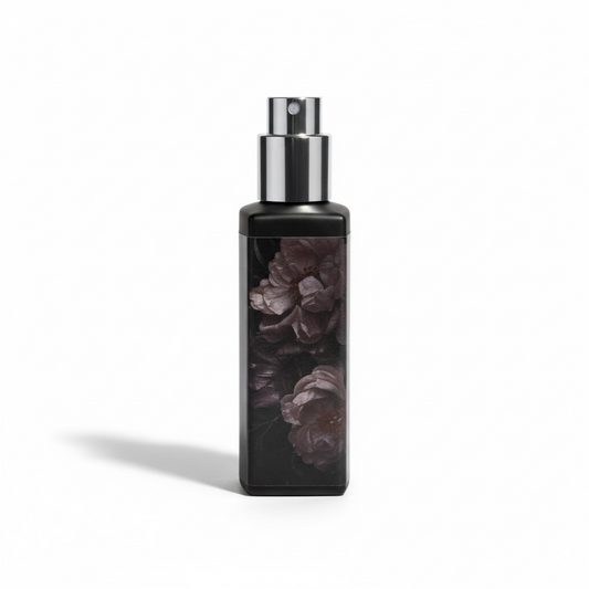Black spray bottle with floral design on a white background