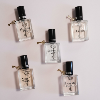 Five perfume bottles with black caps on a light background