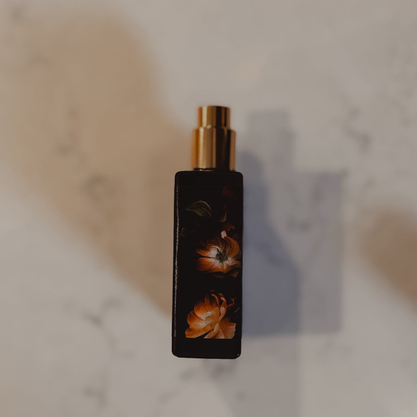 Perfume bottle with floral design on a marble surface