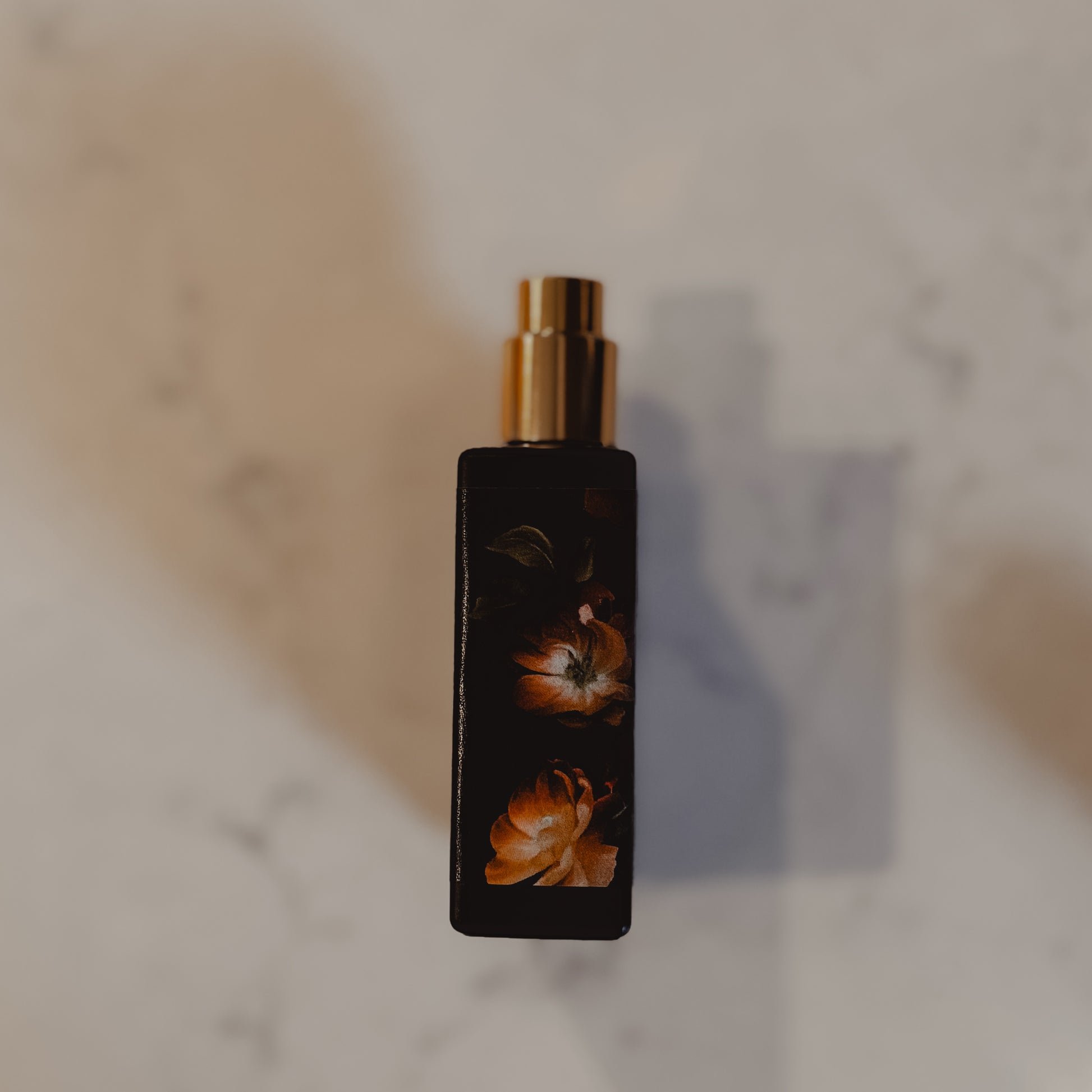 Perfume bottle with floral design on a marble surface