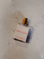 Perfume bottle labeled 'Sunrise Source' on a marble surface