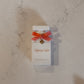 Perfume bottle with 'Honey Veil' packaging on a marble surface