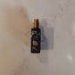 Black spray bottle with floral design on a marble surface