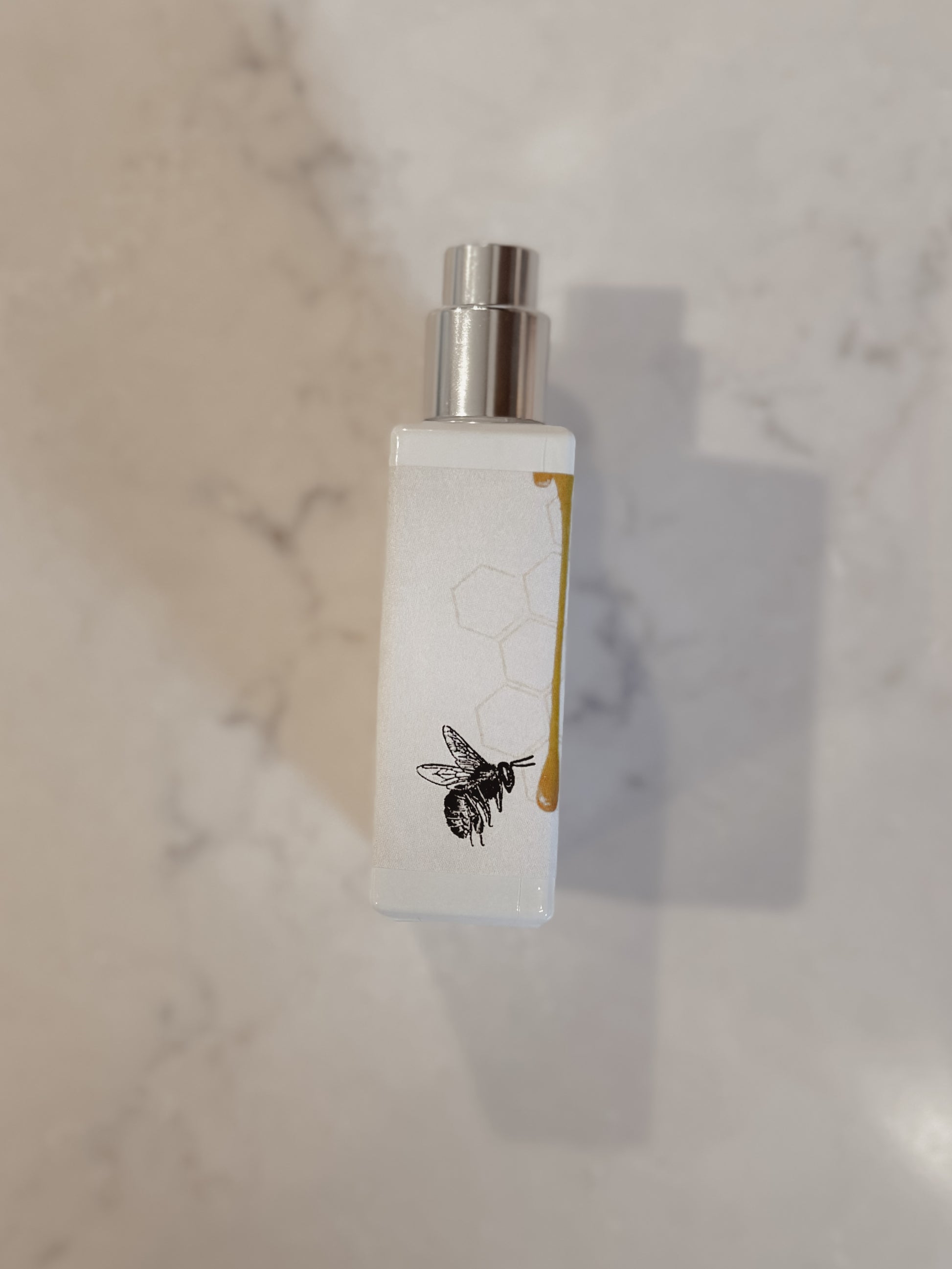 White bottle with silver cap on a marble surface