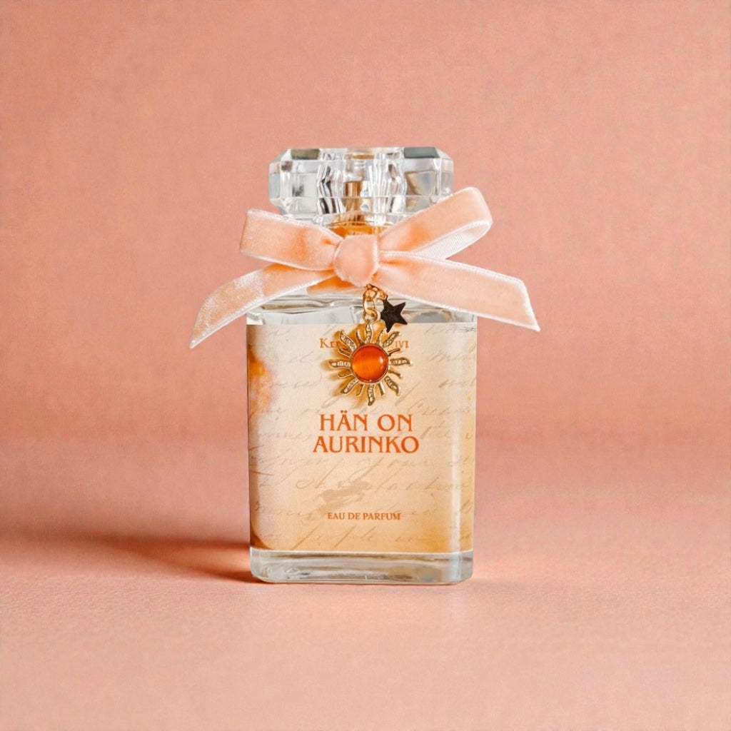 Perfume bottle with a bow and decorative elements on a pink background