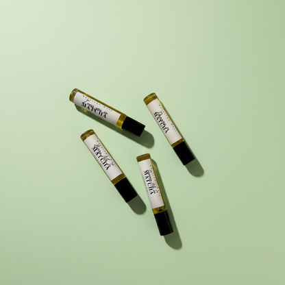Four small cylindrical products with labels on a light green background