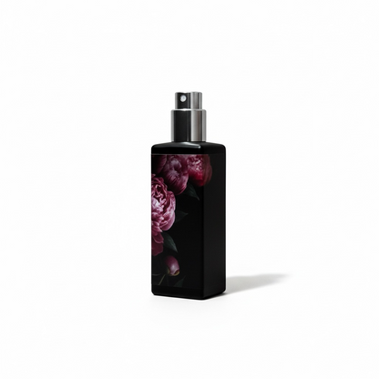Black spray bottle with floral design on a white background