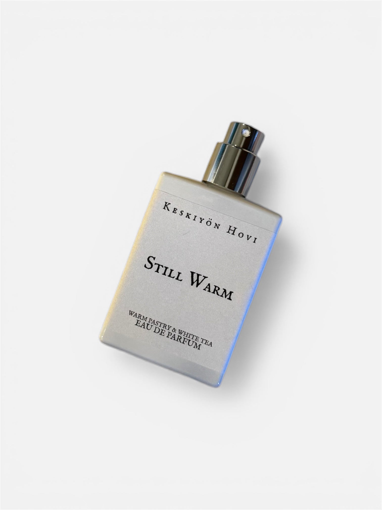 Perfume bottle labeled 'Still Warm' by Keskiyön Hovi on a white background