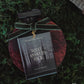 Perfume bottle with a green velvet ribbon on a dark background