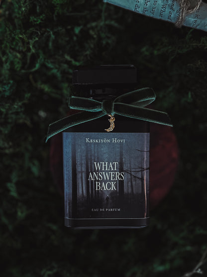 Perfume bottle labeled 'What Answers Back' by Keskiyön Hovi on a dark green textured background