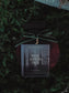 Perfume bottle with a green velvet ribbon on a textured green background