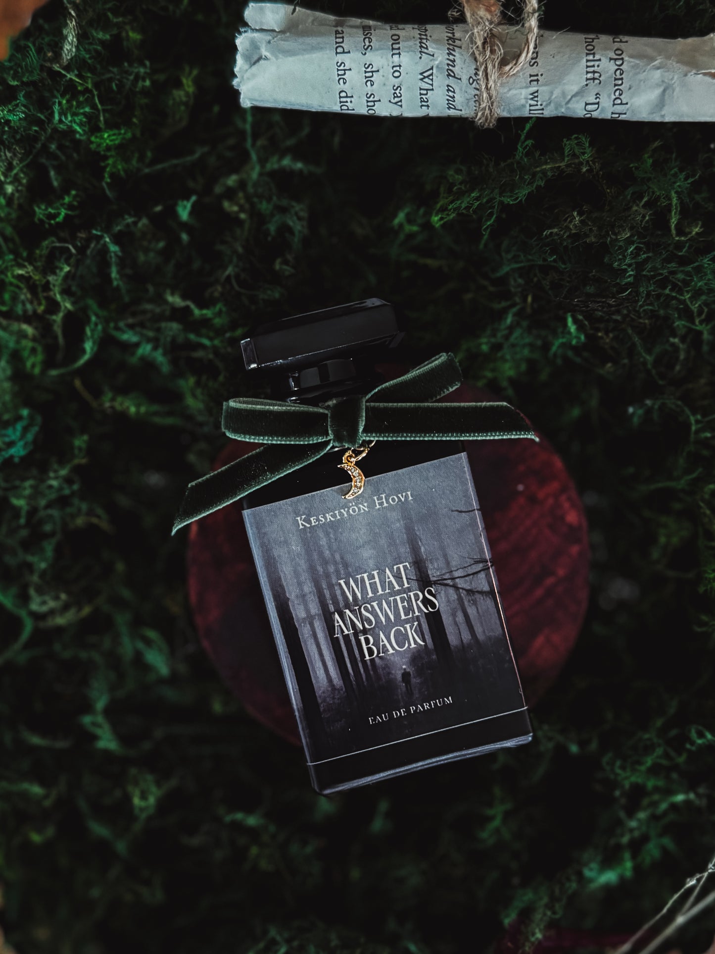 Perfume bottle with a label on a textured green surface