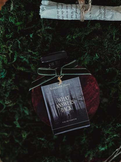 Perfume bottle with a label on a textured green surface