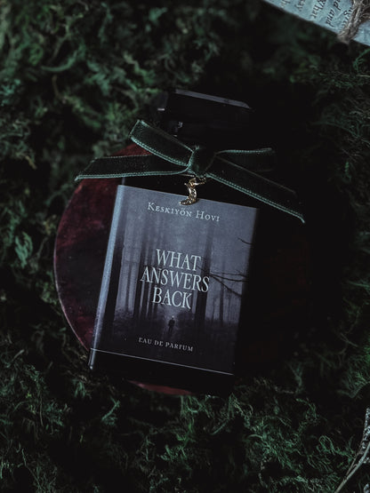 Perfume bottle with a dark label on a green textured surface