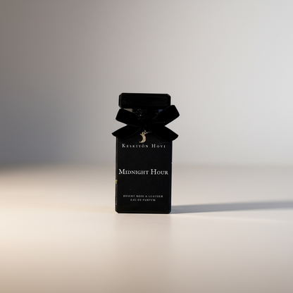Black perfume bottle with bow and 'Kerstin Hovin Midnight Hour' text on a light background