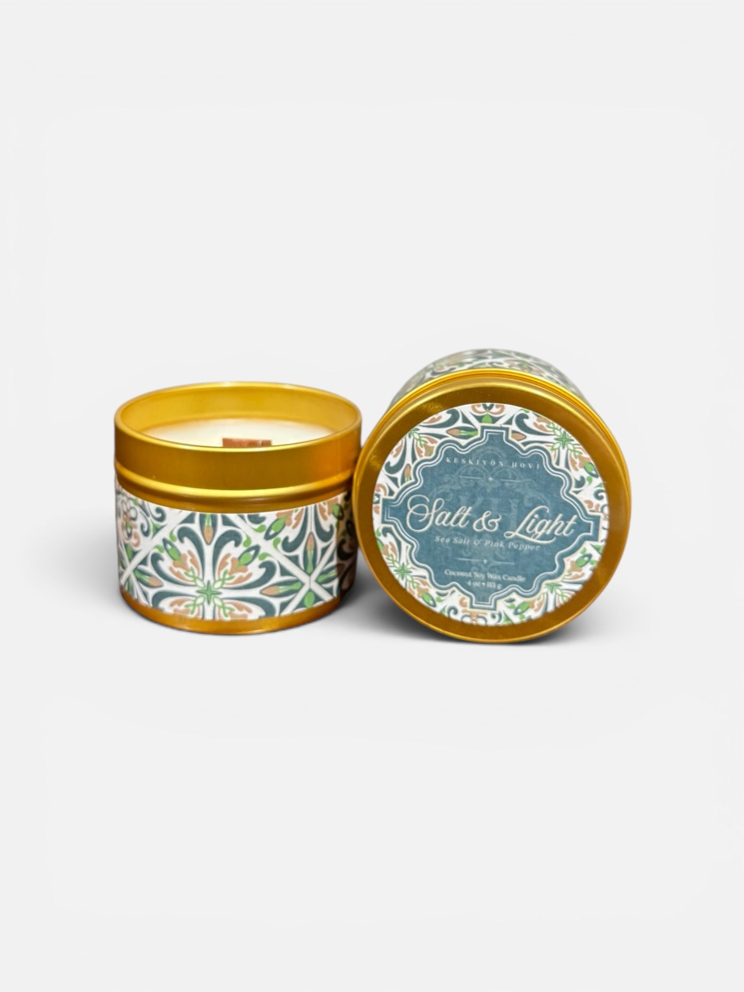 Candle in a decorative tin with 'Salt & Light' branding on a white background